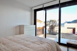 ein Schlafzimmer mit einem Bett und einem großen Fenster in der Unterkunft Casa Paloma in San José