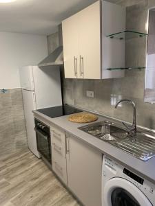 a kitchen with a sink and a washing machine at Casa Antonia in Cazorla