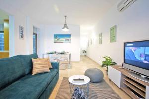 a living room with a green couch and a television at Believe in Dream Apart Contemporâneo com Piscina in Tavira