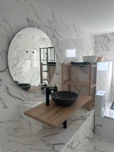 ein Bad mit einem Waschbecken und einem Spiegel in der Unterkunft Apartamentos Buganvilla Roquetas de Mar in Roquetas de Mar