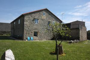 a stone house with a tree in front of it at CASA CONCHA in A Estrada