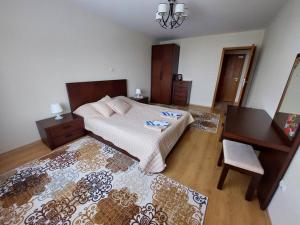 een slaapkamer met een bed, een tafel en een bureau bij Apartment Pirin in Bansko