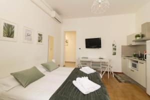 1 Schlafzimmer mit einem großen weißen Bett und einer Küche in der Unterkunft Al Zupgál in Ferrara