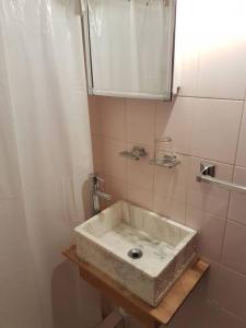 ein Badezimmer mit einem weißen Waschbecken und einem Spiegel in der Unterkunft La Rosadita, un escape tranquilo en La Pedrera. in La Pedrera