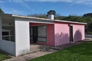 un edificio rosa y blanco con garaje en La Rosadita, un escape tranquilo en La Pedrera., en La Pedrera