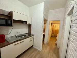 a kitchen with white cabinets and a sink in it at Punta del Este Shelton Hotel in Punta del Este