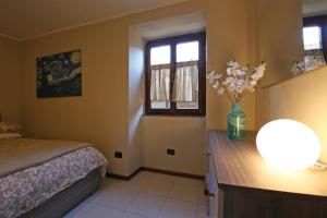 a bedroom with a bed and a desk with a vase of flowers at Bellagio Apartment San Giovanni in Bellagio