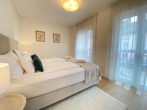 a bedroom with a large bed and a large window at Cosy inner city getaway bestern in Szeged