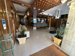 a lobby with a couch and a piano in a building at Punta del Este Shelton Hotel in Punta del Este