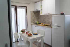 クストナーチにあるCasa Vacanza da Saraのキッチン(テーブル、白い冷蔵庫付)