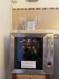 two wine glasses and a small television with a machine at Casa Calma in Colonia del Sacramento