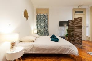 1 dormitorio con 1 cama blanca grande y TV en Ancien Palace Bernascon vue sur lac Classé 3 étoiles, en Aix-les-Bains