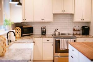 een keuken met witte kasten en een kookplaat oven bij The Cambridge House in Milwaukee