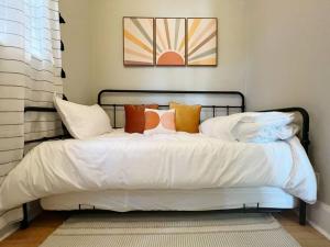 een bed met witte lakens en kussens erop bij The Cambridge House in Milwaukee