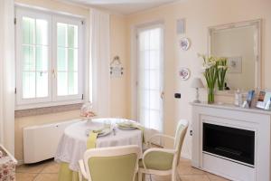 ein Esszimmer mit Tisch und Stühlen und einem Kamin in der Unterkunft Le Gemme Suite B&B in Verona