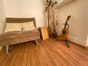 a living room with a couch and a guitar at Casa Calma in Colonia del Sacramento