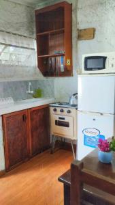 a kitchen with a stove and a white refrigerator at Cabañas Virazon Aguas Dulces in Aguas Dulces