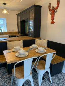 uma sala de jantar com uma mesa de madeira e cadeiras em White Horses Anglesey em Newborough