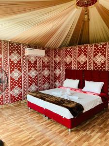 um quarto com uma cama grande numa tenda em Rum Hatem Camp em Wadi Rum