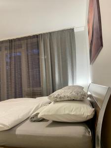 a bed with two pillows in a bedroom with a window at Blue Sky Apartment in Zagreb