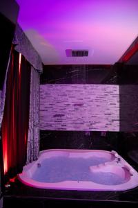 uma casa de banho com uma grande banheira com um tecto roxo em Suite Luxury BDSM em Roma