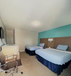 een hotelkamer met 2 bedden en een stoel bij Sand Dollar Motel in Atlantic Beach