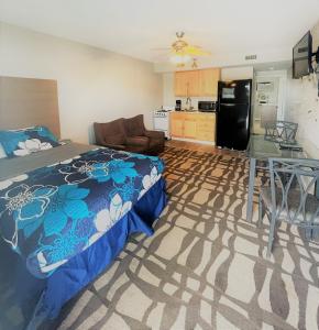 een slaapkamer met een bed en een keuken met een koelkast bij Sand Dollar Motel in Atlantic Beach