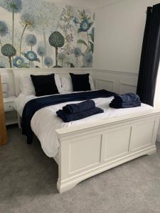 uma cama branca com duas toalhas azuis em cima em White Horses Anglesey em Newborough