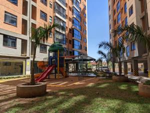 a playground in the middle of a building with palm trees at Bliss haven gardens two bedroom apartment in Nairobi
