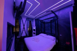 a bedroom with a bed with a purple lighting at Suite Luxury BDSM in Rome