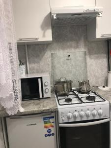 a kitchen with a stove and a microwave at Аэропорт Алматы in (( Turksib ))