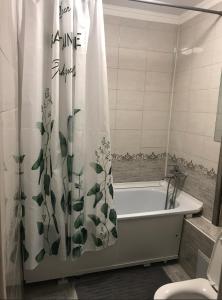 a bathroom with a bath tub with a shower curtain at Аэропорт Алматы in (( Turksib ))