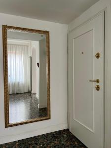 un miroir sur un mur à côté d'une porte dans l'établissement Venice at Home - Rialto Bridge, à Venise