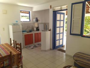 a kitchen with a refrigerator and a table and a door at Villa Campêche Marine in Le Marin