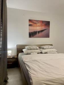 um quarto com uma cama com um quadro na parede em Blue Sky Apartment em Zagreb