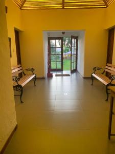 una habitación con 2 bancos y un pasillo con puertas en Bungalows de Casa Verde en Mala