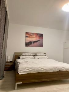 a bedroom with a bed with a painting on the wall at Blue Sky Apartment in Zagreb