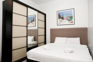 een slaapkamer met een bed en een spiegel bij Sea View Apartment Prime Location On The Beach in Tel Aviv