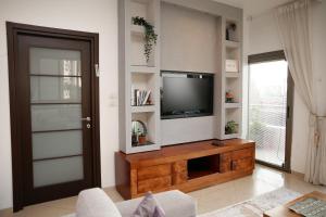 een woonkamer met een televisie op een houten entertainmentcentrum bij Sea View Apartment Prime Location On The Beach in Tel Aviv