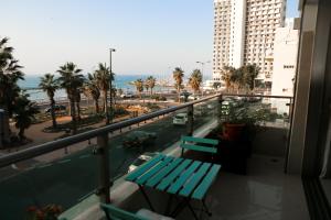 een balkon met 2 banken en uitzicht op de oceaan bij Sea View Apartment Prime Location On The Beach in Tel Aviv