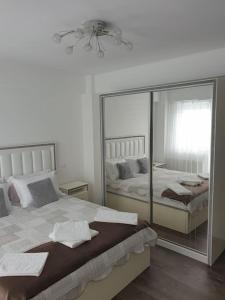 een slaapkamer met 2 bedden en een grote spiegel bij Leaf House in Sibiu
