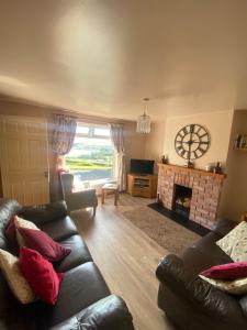 a living room with a couch and a fireplace at Beachview Cottage Co. Antrim in Cushendun