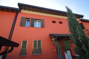 a red building with windows and a tree at Casa Ol Gàl in Bergamo