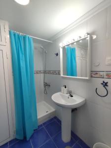 baño con lavabo y cortina de ducha azul en Apartamento primera línea - Playa Patalavaca, en Patalavaca