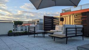 patio z 2 krzesłami i parasolem na dachu w obiekcie Luxurious villa-apartment with spacious terrace w Pradze