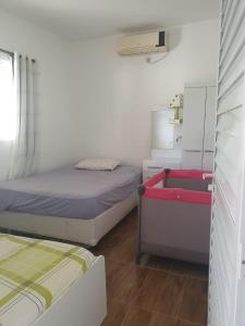 A bed or beds in a room at Casa proxima a Praia do Rosa e Barra de Ibiraquera 2 quartos com ar condicionado