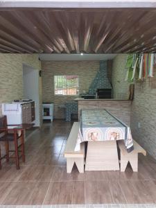 a large room with a table and a kitchen at Casa proxima a Praia do Rosa e Barra de Ibiraquera 2 quartos com ar condicionado in Imbituba