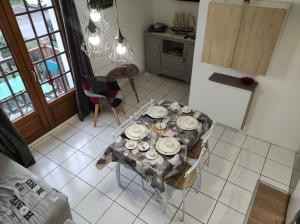 una cocina con una mesa con platos. en APPT 4P - Manoirs 1 à la Mer Chez Claudette & Marc, en Courseulles-sur-Mer