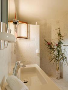 a bathroom with a sink and a potted plant at Residence Maïna in Cargèse