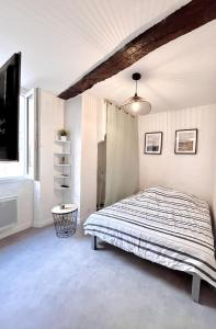 1 dormitorio con 1 cama y TV de pantalla plana en studio en Duplex en La Roquebrussanne